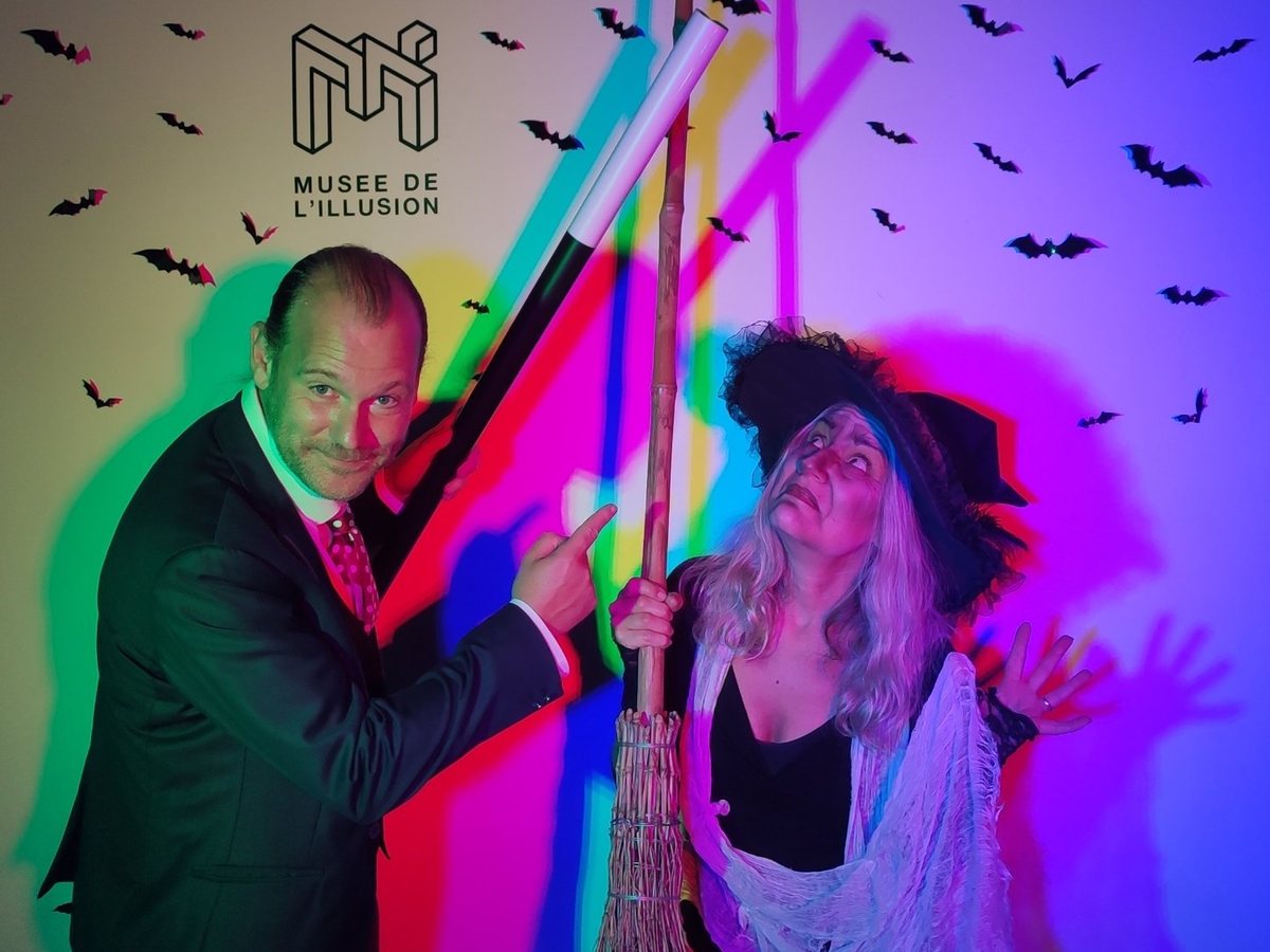 Anthony James, magicien, et une sorcière devant le mur d'Halloween du Musée de l'Illusion de Lyon